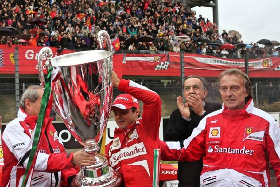 Marchionne applaude Felipe Massa insieme a Luca Cordero di Montezemolo alle premiazioni dei campionati Ferrari Challenge del Mugello, novembre 2013. Ansa